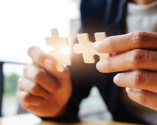 Business woman hands connecting jigsaw puzzle. Business solutions, success and strategy concept. Businessman hand connecting jigsaw puzzle.Close up photo with selective focus.